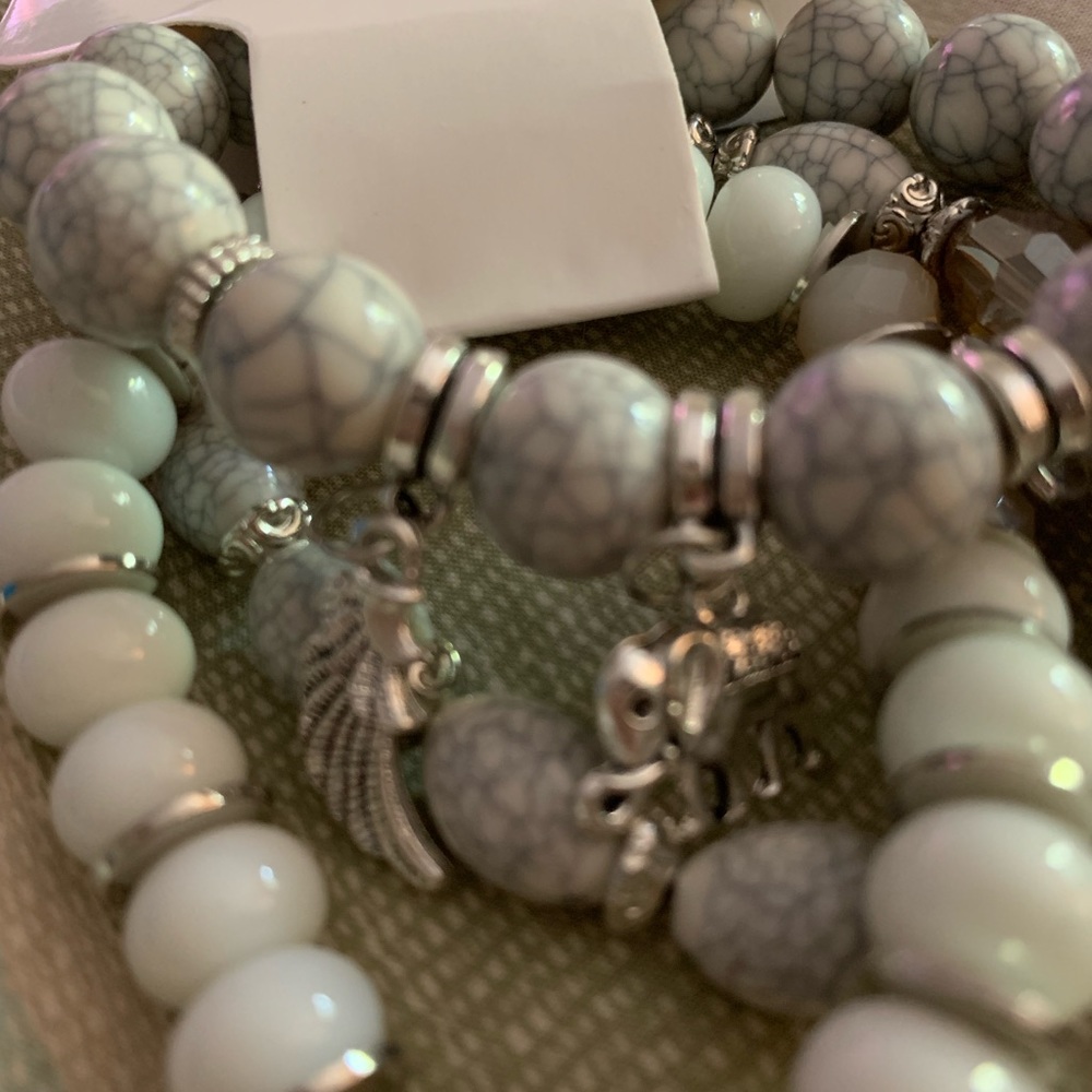Silver and white stretchy bracelet with charms.